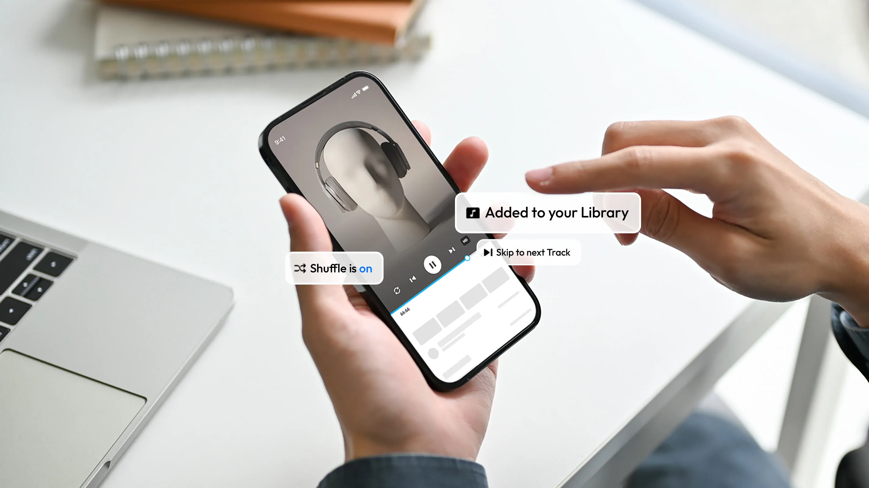 A person holds a smartphone displaying a music app, with floating UI microcopy examples: 'Shuffle is on', 'Added to your Library' and 'Skip to next Track'.