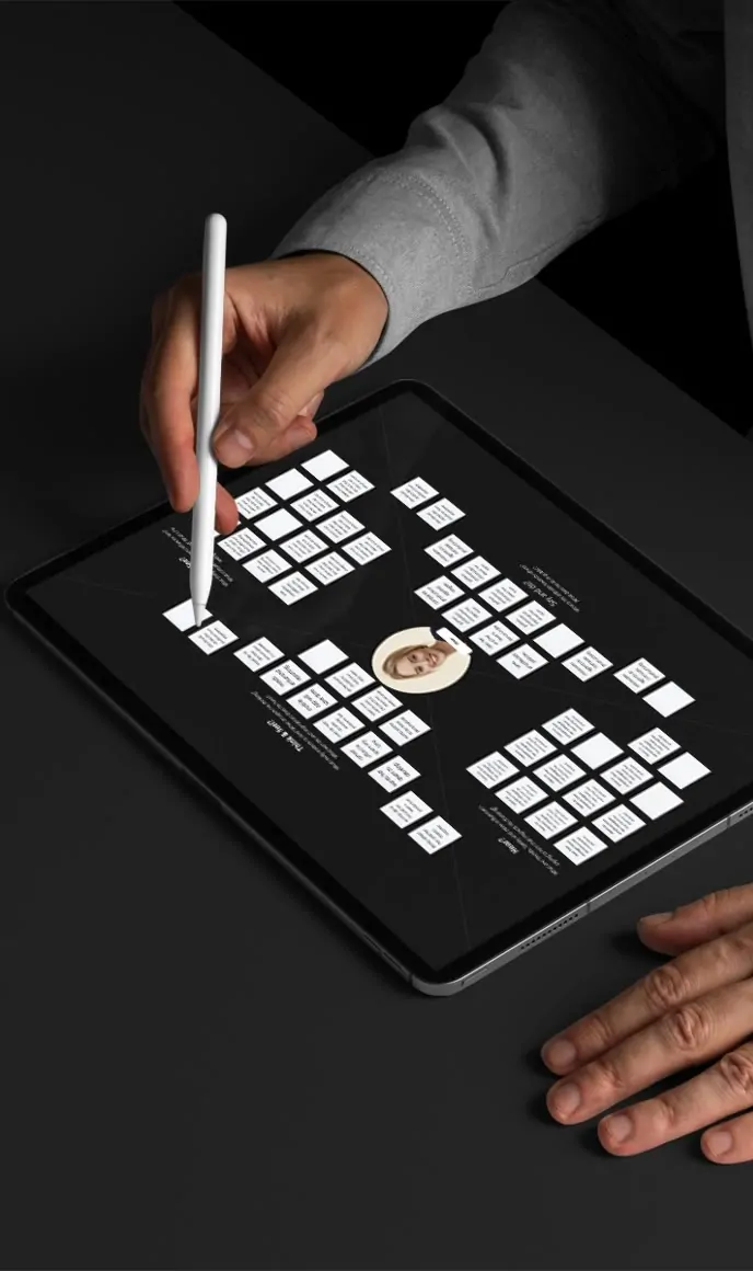 Hands using a stylus to review a user flow diagram on a tablet.