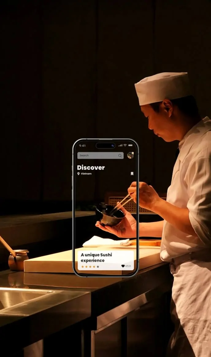 A mobile app UI mockup displayed in front of a chef working in a professional kitchen.